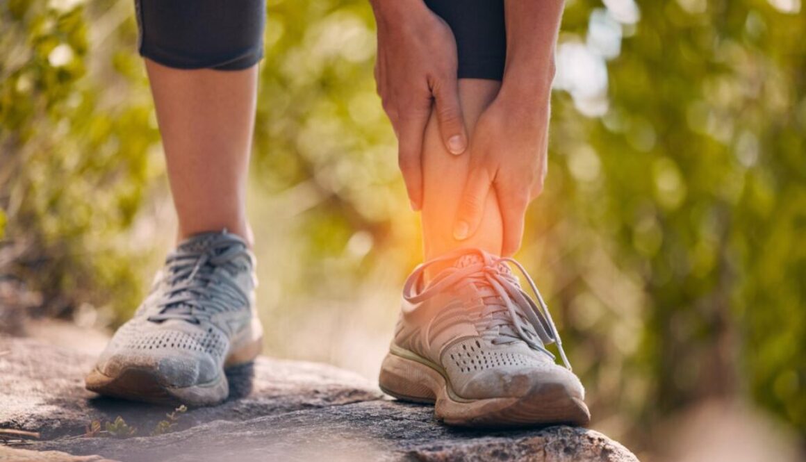 Athlete, ankle and joint injury on nature walk workout with muscle cramps and strain close up. Inflammation, pain and physical trauma to body while trekking outdoors in park for fitness.